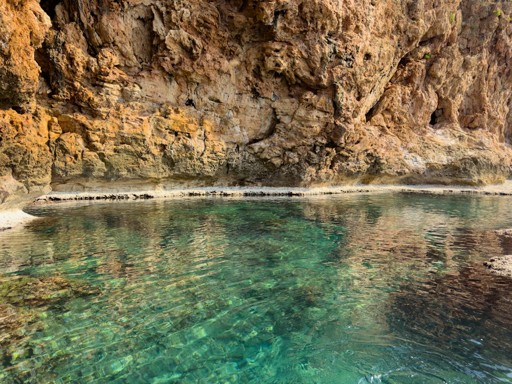 Eau cristalline au pied des falaises ocre — balade en mer dans les Calanques