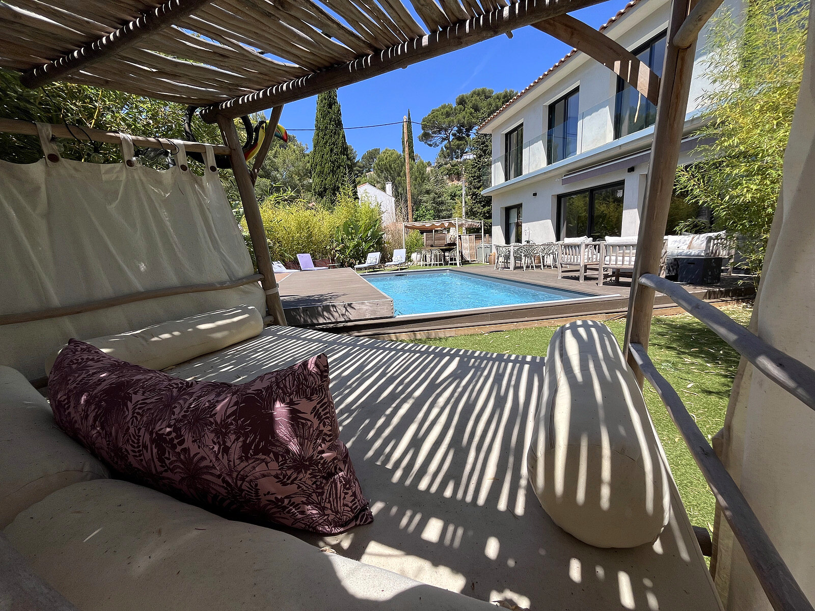Coin lounge sous pergola en bois avec vue piscine — espace détente villa Cassis